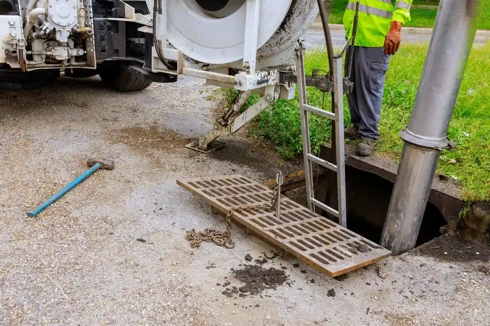 Industrial sewer cleaning truck clearing a blockage at a manhole.