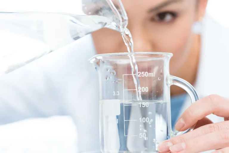 Water sample being poured into a beaker for water quality testing.