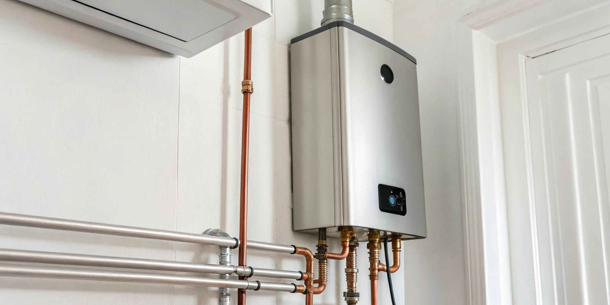 An installed electric tankless water heater, showing how to connect the plumbing and electrical lines.