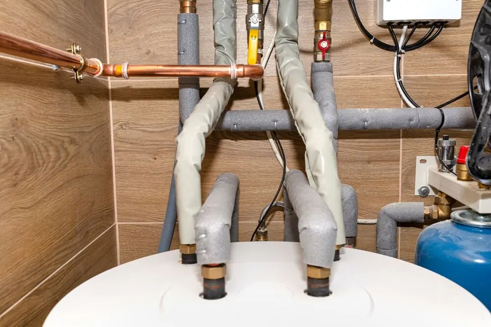 Copper gas pipes connected to water heaters in a home boiler room.